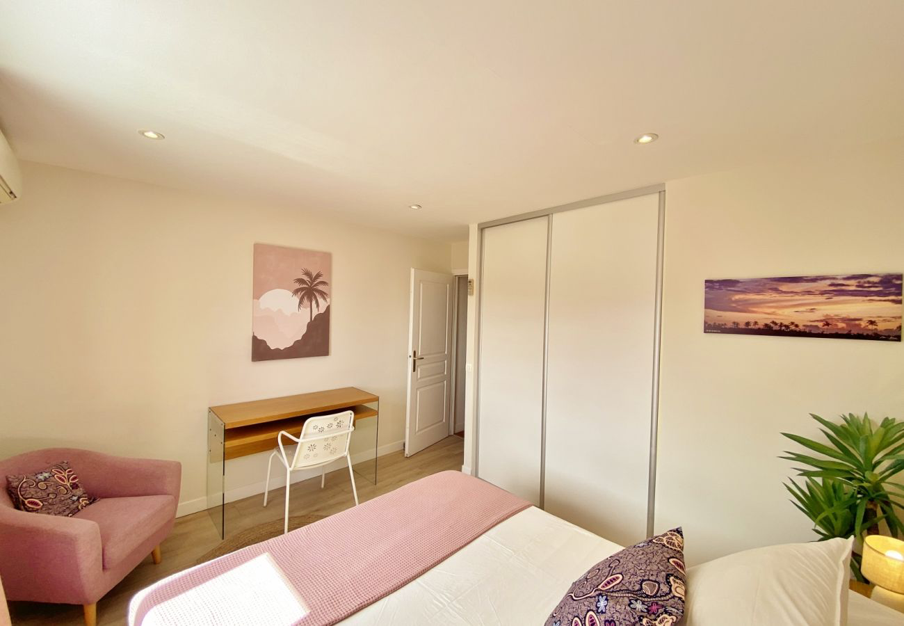 Chambre de la Villa Oryzea avec coin bureau, fauteuil et grands placards