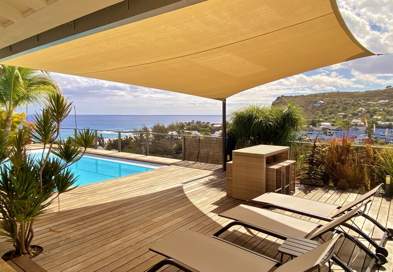 Terrasse panoramique avec transats, piscine chauffée et vue sur l'océan Indien